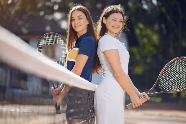 写真のためにポーズをとっているテニスコートの2人の女性テニス選手 — ストック写真