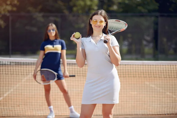 Dvě hráčky tenisu na tenisovém kurtu pózují pro focení — Stock fotografie