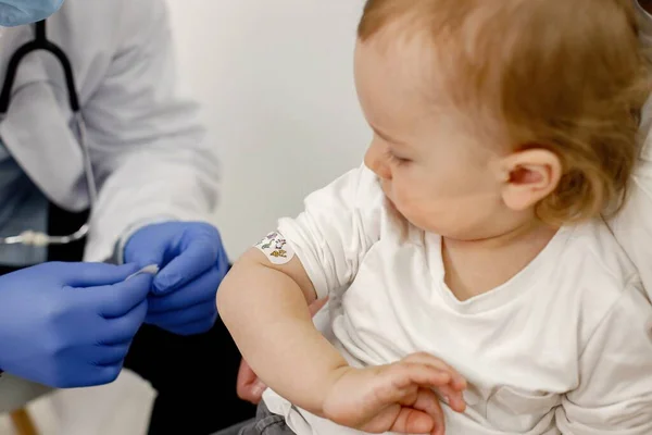 Cropped photo of a boys shoulder with stick band-aid vaccination — Stockfoto