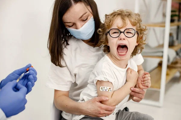 Маленький хлопчик кричить, тому що лікар збирається зробити вакцинацію — стокове фото