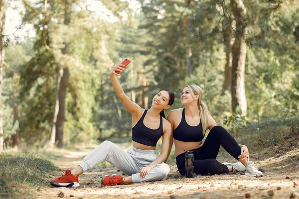 Mulheres bonitas passam tempo em um parque de verão — Fotografia de Stock