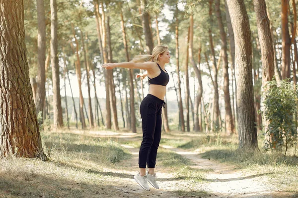 Söt tjej som gör yoga i en sommarskog — Stockfoto