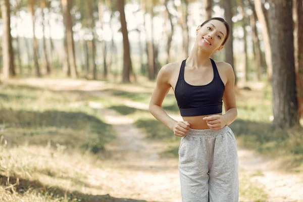 Mulher bonita corre em um parque de verão — Fotografia de Stock