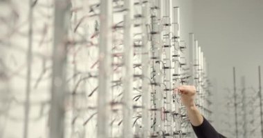 Tatlı kızı olan ebeveynler modern bir optik mağazasında gözlük deniyorlar.