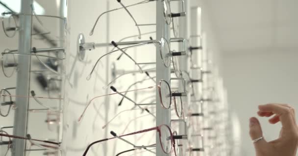Närbild av en optiker tar bort glasögon från ett skyltfönster. — Stockvideo