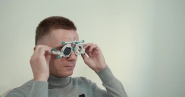 Ofiste kısa saçlı genç bir adam gözleri kontrol ediyor.