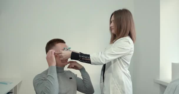 Young man with a short haircut in the office checking eyesight — Video