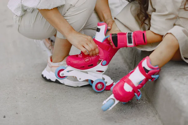 Mother with daughter in a summer park with roller — Stock fotografie