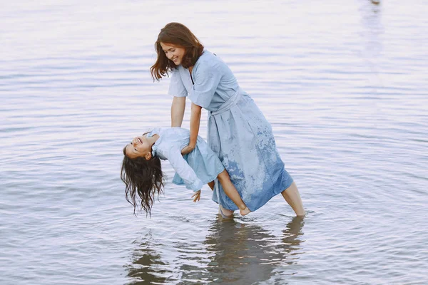 Mother with daughter playing in the little river — 스톡 사진