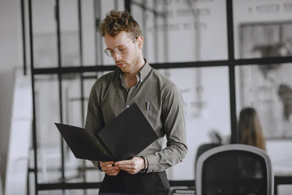 Man in a suit holds a folder. — Stockfoto