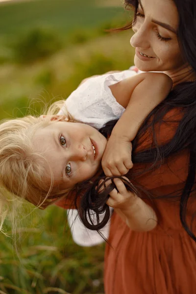 Mor med liten dotter som leker på ett sommarfält — Stockfoto
