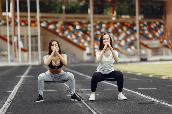 Two sports girls in a uniform training at the stadium — Stok fotoğraf