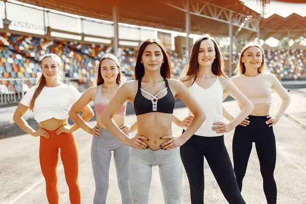 Five sports girls in a uniform training at the stadium — Stockfoto