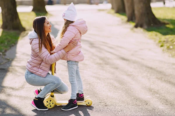 Mutter mit Tochter im Frühlingspark mit Skate — Stockfoto