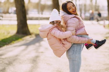 Anne ve kızı bir bahar parkında oynuyorlar.