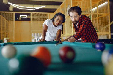 Uluslararası çift bir kulüpte bilardo oynuyor.