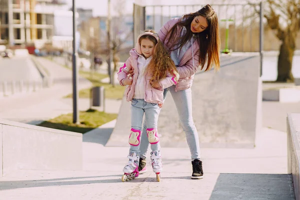 Madre con hija en un parque de primavera con rodillo — Foto de Stock