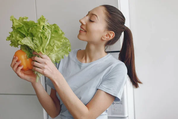 Belle fille sportive dans une cuisine avec un légume — Photo