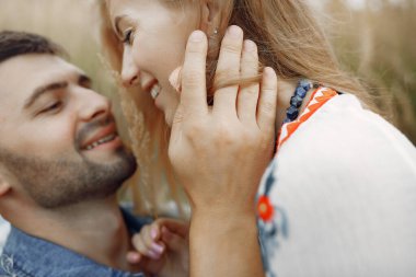 Buğday tarlasında birbirini seven bir çift. Mavi şapkalı güzel sarışın..