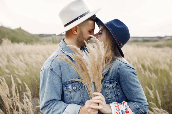 小麦畑でカップルを愛しています 美しいですブロンドで青帽子 — ストック写真