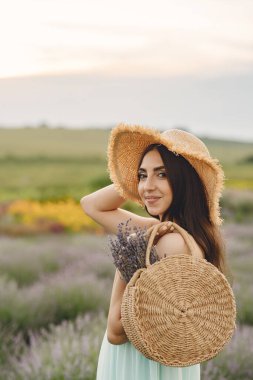 Provence 'lı kadın lavanta tarlasında dinleniyor. Hasır şapkalı kadın. Çantalı kız..