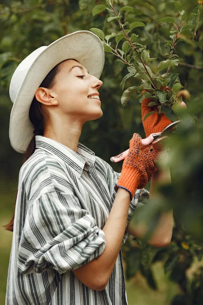 Wanita Muda Mengurus Tanaman Brunette Dengan Topi Dan Sarung Tangan — Stok Foto