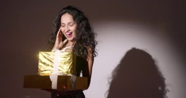 Kadın karanlık bir stüdyonun spot ışıklarında duruyor. O, Noel ya da yeni yıl hediye kutuları tutuyor. Parti, kutlama tanıtımı..