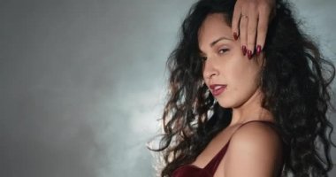 Kız spot ışıklarına karşı tutkuyla dans ediyor. Stüdyo ayarları. Işık ve duman..