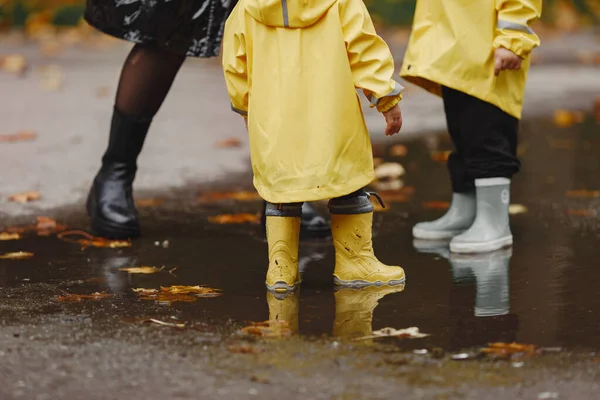 Børn Efterårspark Børn Gule Regnfrakker Folk Har Det Sjovt Udendørs - Stock-foto