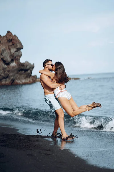 在巴厘岛的一个僻静的私人海滩上 一对情侣正在放松 在一个隐蔽的海滩上示爱的夫妻 穿浴衣的夫妻 — 图库照片