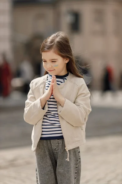 Mała Dziewczynka Ukraińską Flagą Policzku Stojąca Ulicy Młoda Ślicznotka Modli — Zdjęcie stockowe