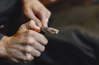 Berber dükkanı. Berberin yakın çekimi sakalını tıraş etmek için jilet tutuyor.