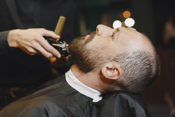 Man with a beard. Hairdresser with a client. Man with a shave.