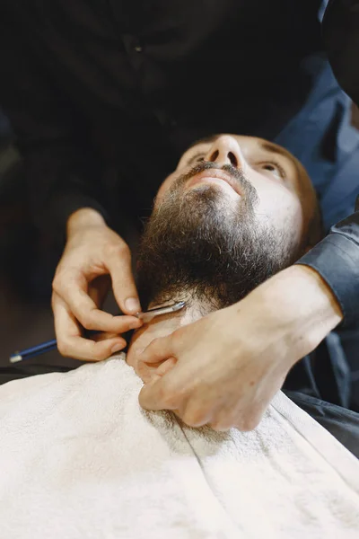 Man with a beard. Hairdresser with a client. Man with a shave.