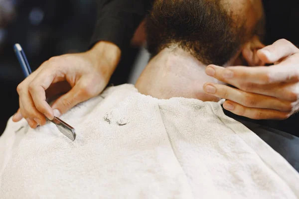 Man with a beard. Hairdresser with a client. Man with a shave.