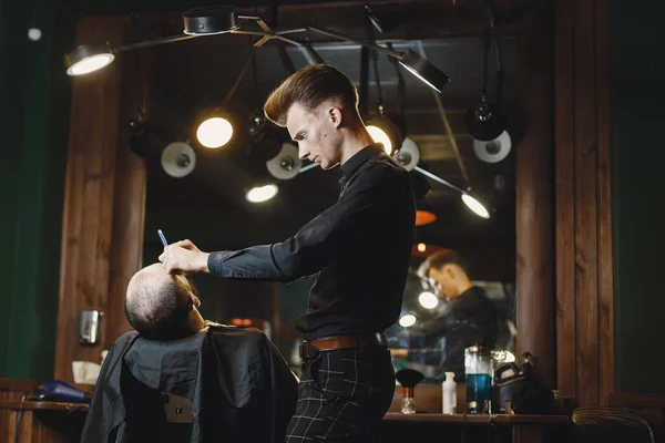 Man with a beard. Hairdresser with a client. Man with a shave.