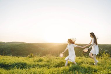 Buğday tarlasında iki güzel kız kardeş. Uzun, sağlıklı saçları olan iki güzel kız yazın doğanın tadını çıkarıyor..