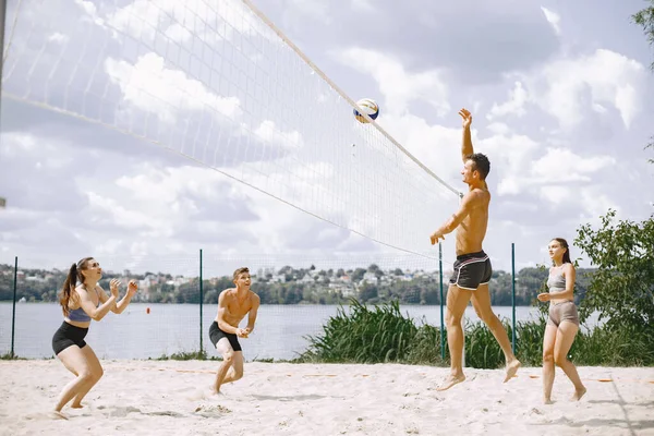 Sports and active life theme. Young players play volleyball. Beach playground.