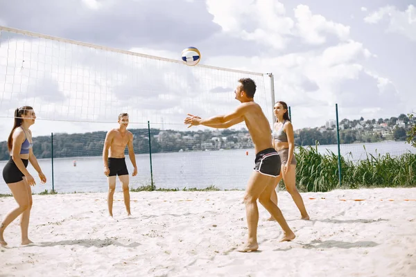 Sports and active life theme. Young players play volleyball. Beach playground.