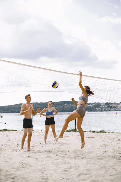 Sports and active life theme. Young players play volleyball. Beach playground.