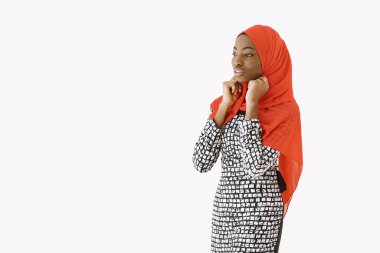 Hoş, dindar Müslüman bir kadının resmi. Nazik bir gülümsemesi, koyu sağlıklı bir teni var. Kafasına eşarp takıyor. Beyaz arkaplan üzerinde izole edilmiş.