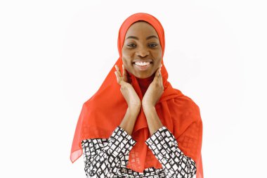 Hoş, dindar Müslüman bir kadının resmi. Nazik bir gülümsemesi, koyu sağlıklı bir teni var. Kafasına eşarp takıyor. Beyaz arkaplan üzerinde izole edilmiş.