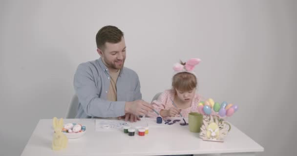 Father Daughter Doen Syndrome Painting Easter Colored Eggs Sitting Table — Vídeos de Stock