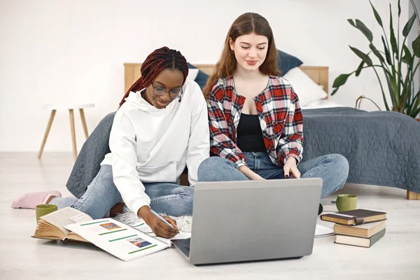 Dwie Młode Kobiety Siedzące Podłodze Koło Łóżka Laptopem Domu Czarna — Zdjęcie stockowe