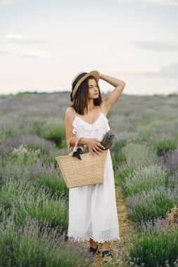 Provence 'lı kadın lavanta tarlasında dinleniyor. Beyaz elbiseli kadın. Çantalı kız..