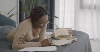 College or high school girl studies at home. Black race. Searching for ideas, homework, classes.
