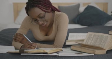 College or high school girl studies at home. Black race. Searching for ideas, homework, classes.