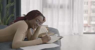 College or high school girl studies at home. Black race. Searching for ideas, homework, classes.