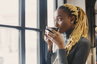 İnsanlar ve eğlence konsepti. Güzel Afrikalı kızın vesikalığı. Gri kazaklı kadın.