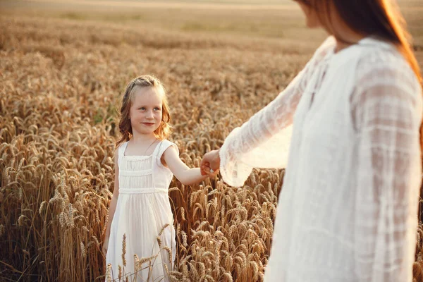 Family in a summer field. Sensual photo. Cute little girl. Woman in a white dress.